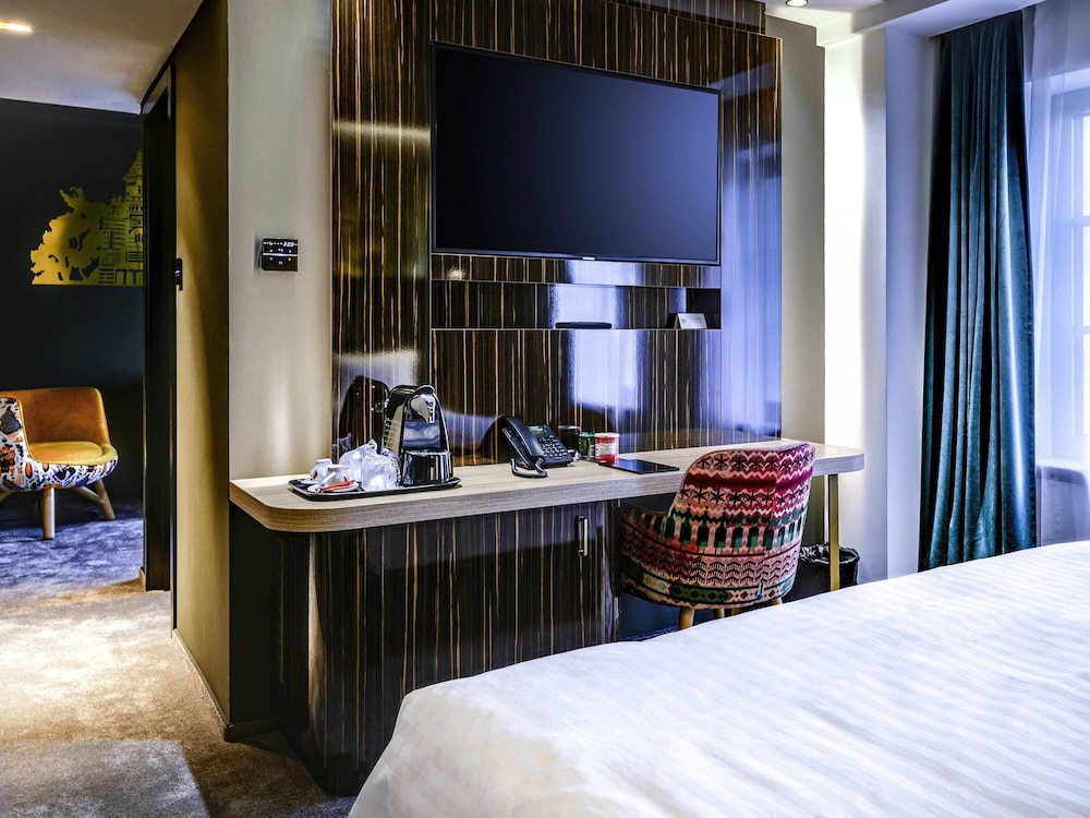 Habitación superior con 1 cama king size y sofá del hotel Mercure Timisoara