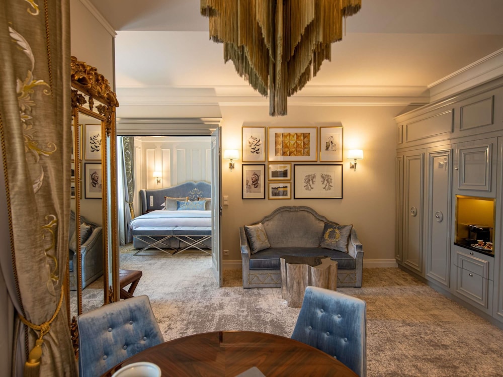 Suite Executive con cama king size y sala de estar con sofá del hotel Bachleda Luxury Hotel Krakow - MGallery Collection. Foto 4