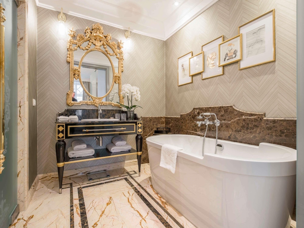 Suite Executive con cama king size y sala de estar con sofá del hotel Bachleda Luxury Hotel Krakow - MGallery Collection. Foto 6