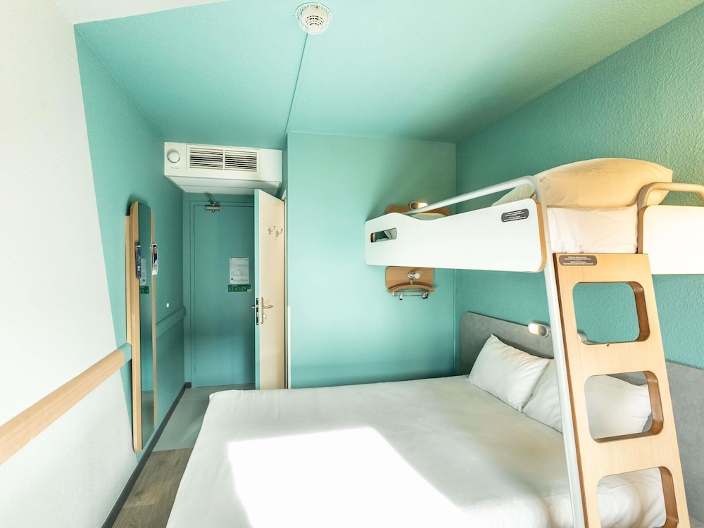 TRIPLE - Habitación con una cama grande y una litera del hotel Ibis Budget Bourges. Foto 6