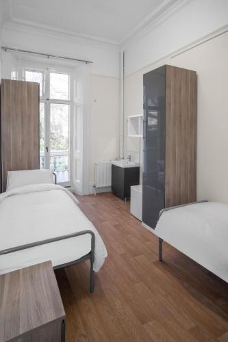 Cama individual en habitación doble masculina del hotel Holland House - Hostel