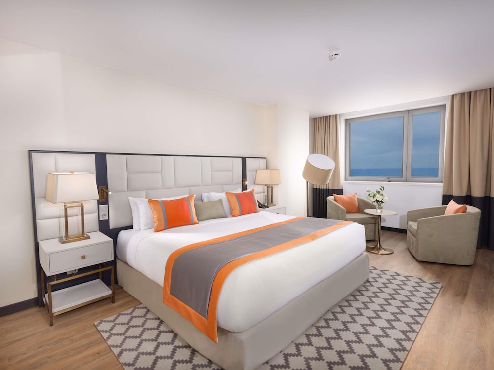 Suite Junior con cama King Size, sofá y vistas al océano del hotel Mercure Alger Palais Des Congres