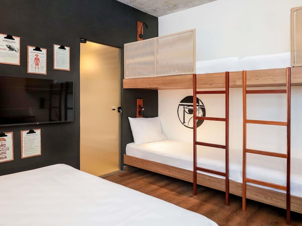 Habitación con 1 cama doble, 2 camas tipo litera y vistas al mar del hotel Ibis Styles Maceió Pajuçara. Foto 1