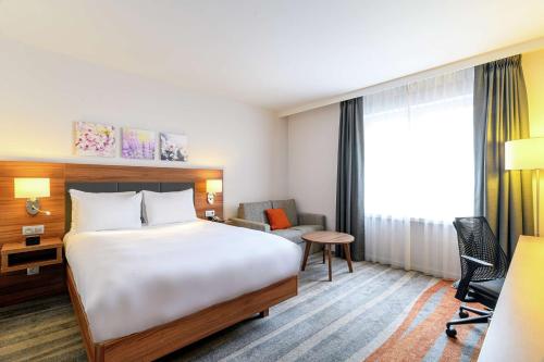 Habitación con cama extragrande y sofá cama del hotel Hilton Garden Inn Brussels City Centre