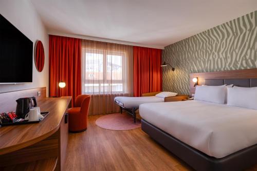 Habitación con cama extragrande y sofá cama del hotel Hilton Garden Inn Brussels City Centre. Foto 1