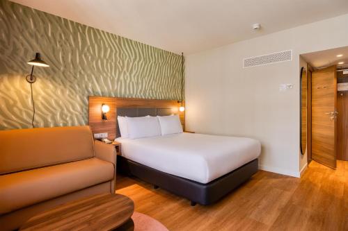 Habitación con cama extragrande y sofá cama del hotel Hilton Garden Inn Brussels City Centre. Foto 2