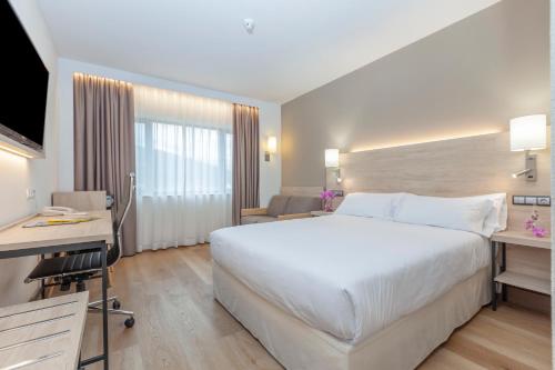 Habitación Deluxe con cama grande y sofá del hotel Puerta De Bilbao