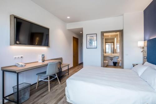 Habitación Deluxe con cama grande y sofá del hotel Puerta De Bilbao. Foto 2