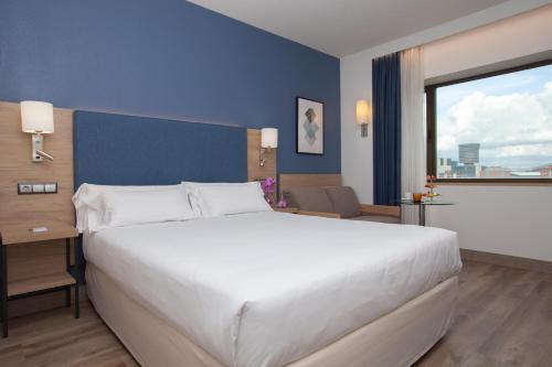 Habitación Deluxe con cama grande y sofá del hotel Puerta De Bilbao. Foto 6