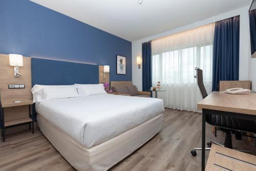 Habitación Deluxe con cama grande y sofá del hotel Puerta De Bilbao. Foto 7