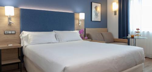 Habitación Deluxe con cama grande y sofá del hotel Puerta De Bilbao. Foto 8