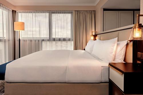 Suite Junior con cama extragrande, vistas panorámicas y acceso al salón del hotel Hilton Vienna Park