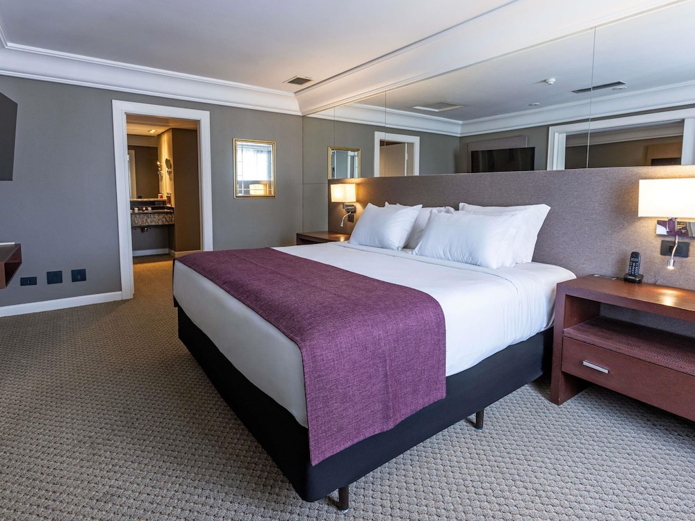 Suite Luxury con 1 cama king size, sofá cama y bañera de inmersión del hotel Grand Mercure Curitiba Rayon. Foto 8