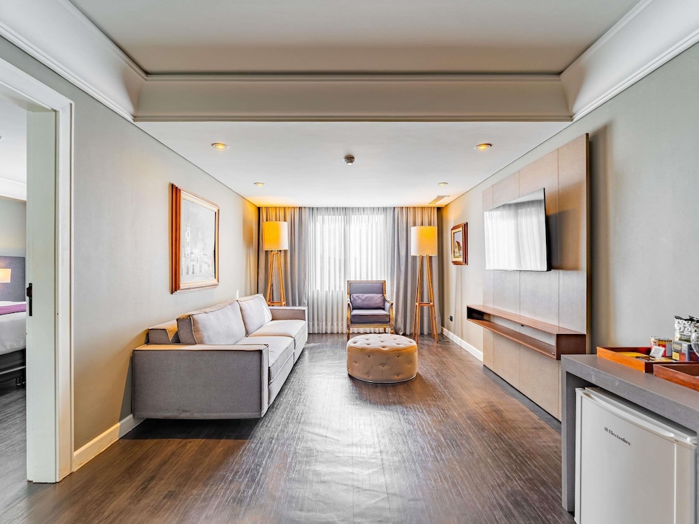 Suite Luxury con 1 cama king size, sofá cama y bañera de inmersión del hotel Grand Mercure Curitiba Rayon. Foto 12