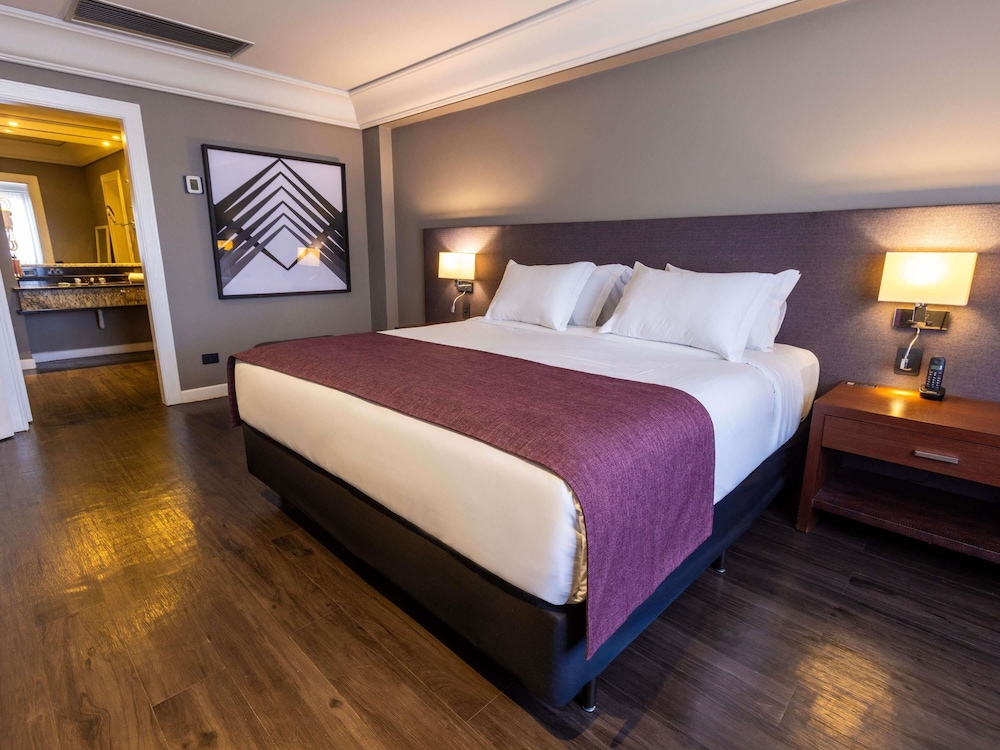 Suite Luxury con 1 cama king size, sofá cama y bañera de inmersión del hotel Grand Mercure Curitiba Rayon. Foto 9