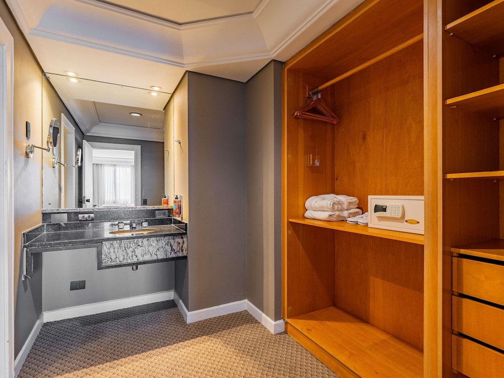Suite Luxury con 1 cama king size, sofá cama y bañera de inmersión del hotel Grand Mercure Curitiba Rayon. Foto 11