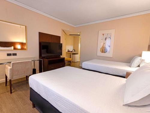 Habitación comunicada con 1 cama queen - size y 2 camas individuales del hotel Grand Mercure Curitiba Rayon. Foto 2