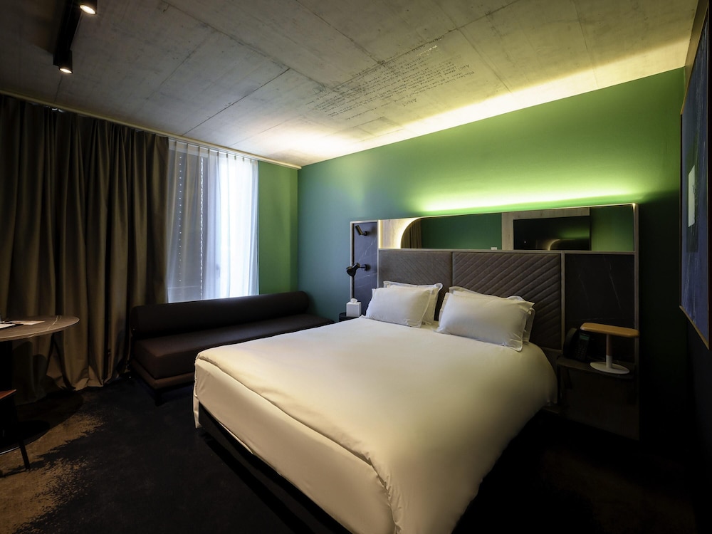 Habitación Clásica con cama queen size y sofá del hotel Mercure Delémont