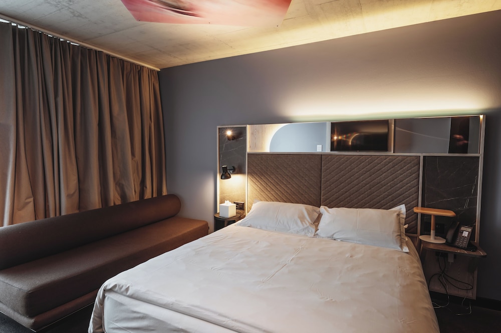 Habitación Clásica con cama queen size y sofá del hotel Mercure Delémont. Foto 1