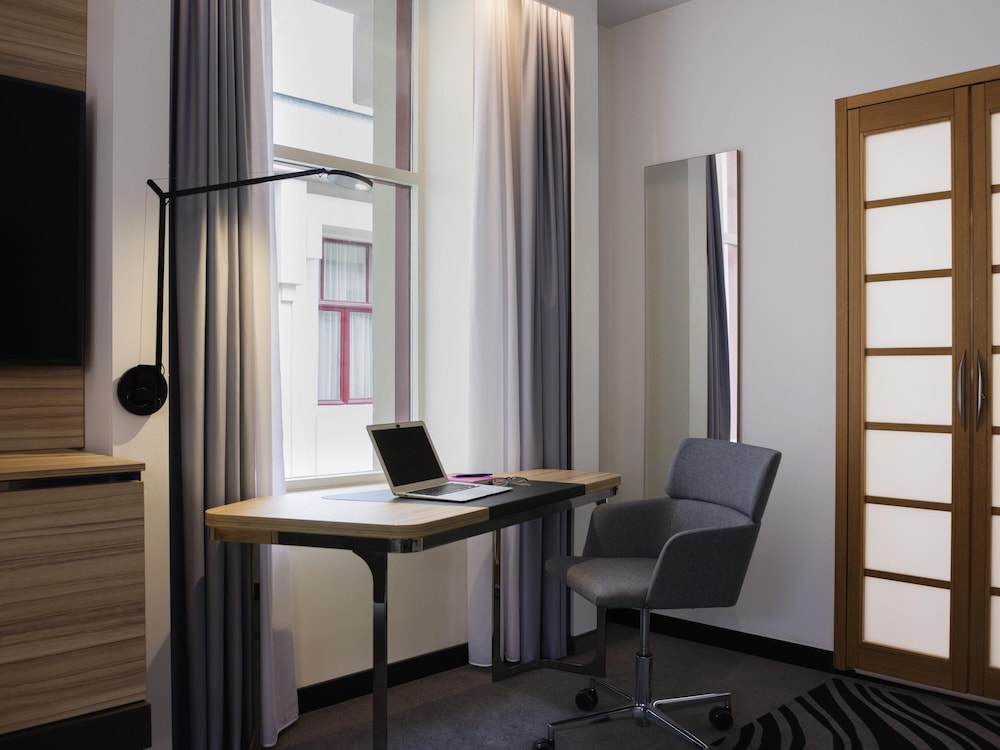 Suite Superior con 1 cama doble y sofá del hotel Novotel Den Haag City Centre. Foto 4