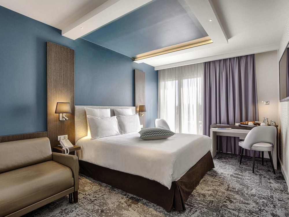 Habitación superior con cama doble y sofá, y acceso al spa del hotel Mercure Cabourg and Spa