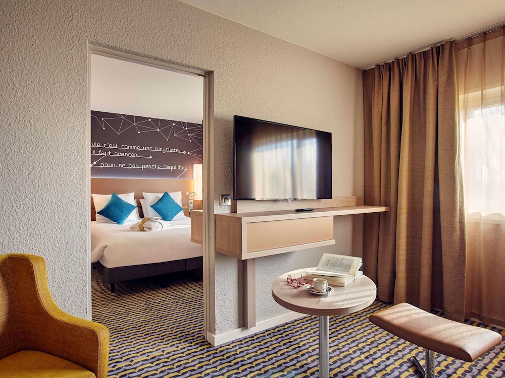 Suite Junior con una cama doble y un sofá cama doble del hotel Hotel Mercure París Sur Les Ulis Courtaboeuf