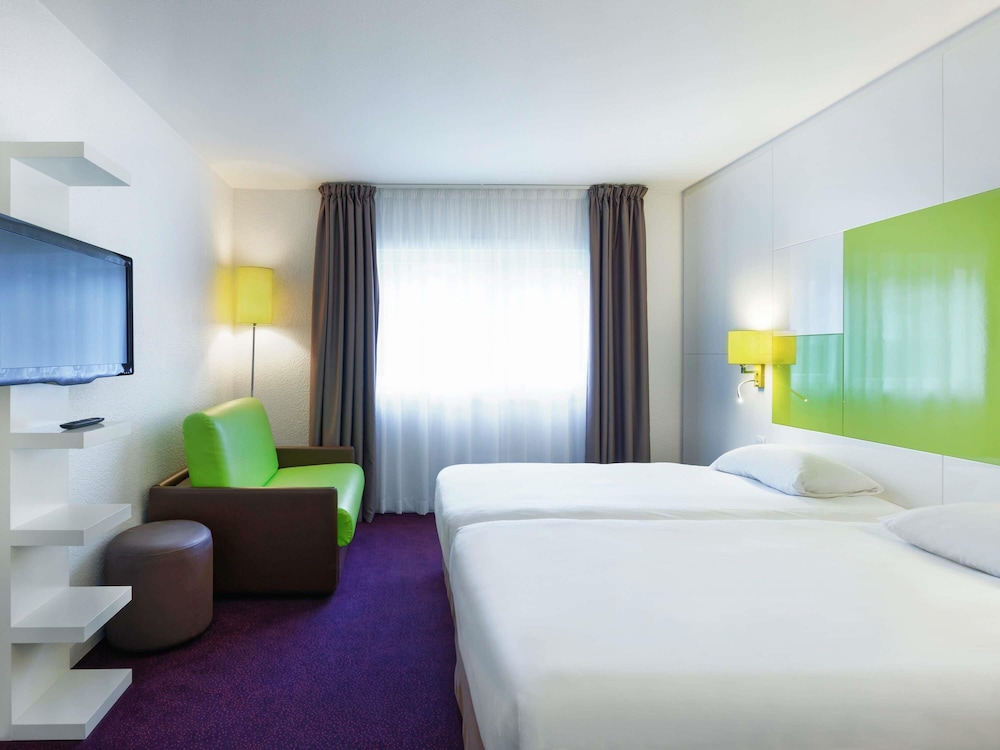 Habitación con 1 cama doble y 1 sofá cama del hotel Ibis Styles Chalon Sur Saone