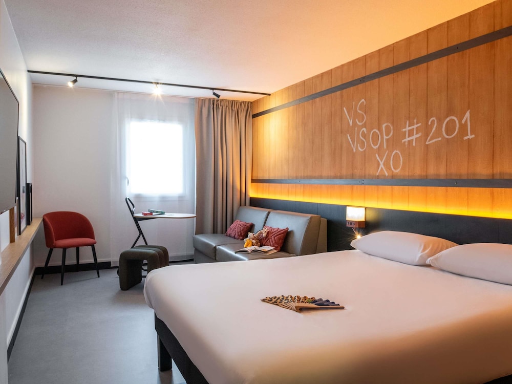Habitación familiar con una cama doble y un sofá del hotel Ibis Styles Cognac. Foto 8