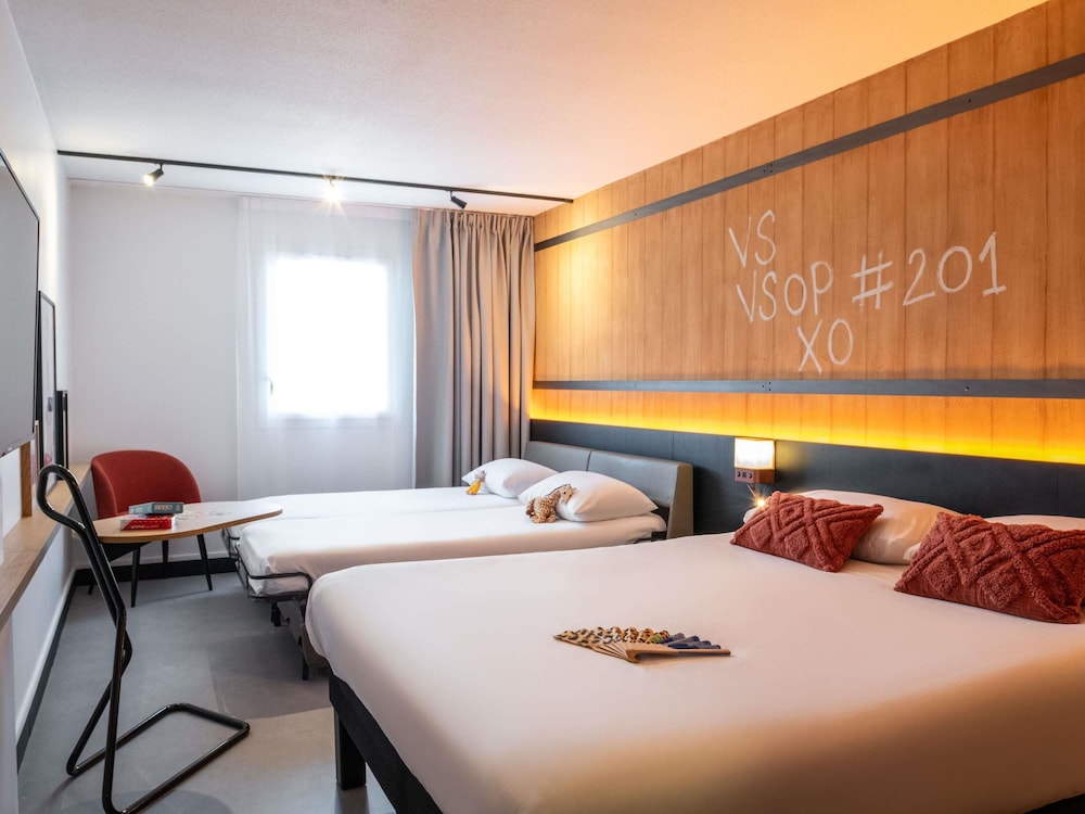 Habitación familiar con una cama doble y un sofá del hotel Ibis Styles Cognac. Foto 9