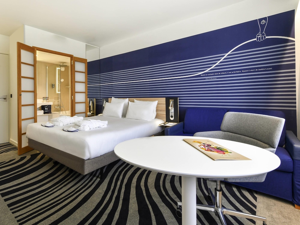 Habitación Executive con una cama doble y sofá del hotel Novotel La Rochelle Centre