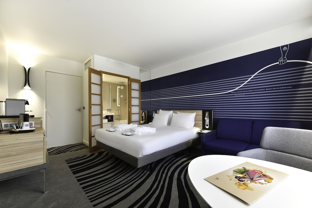 Habitación Executive con una cama doble y sofá del hotel Novotel La Rochelle Centre. Foto 1