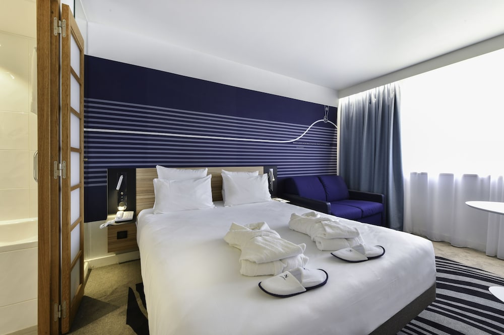 Habitación Executive con una cama doble y sofá del hotel Novotel La Rochelle Centre. Foto 2