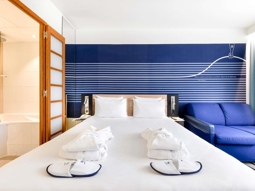 Habitación Executive con una cama doble y sofá del hotel Novotel La Rochelle Centre. Foto 4