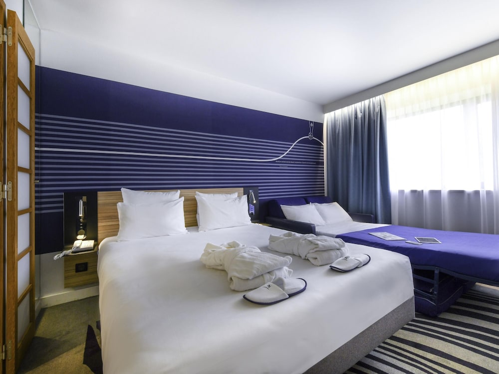 Habitación Executive con una cama doble y sofá del hotel Novotel La Rochelle Centre. Foto 6