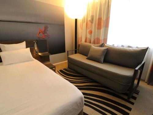 Habitación Classic con 1 cama doble y 2 sofás cama individuales del hotel Novotel Limoges Le Lac. Foto 1