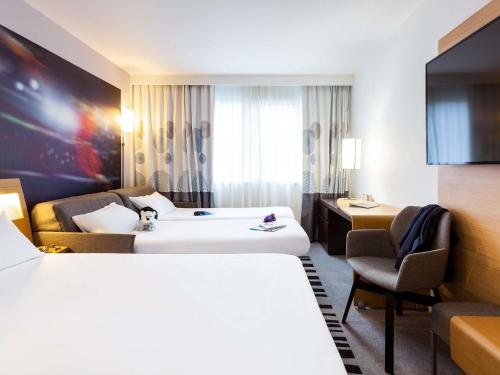 Habitación Classic con 1 cama doble y 2 sofás cama individuales del hotel Novotel Limoges Le Lac. Foto 4