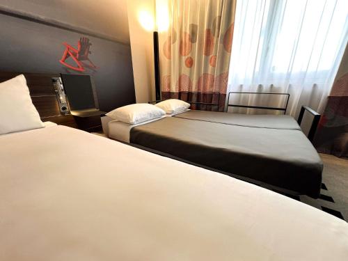 Habitación Classic con 1 cama doble y 2 sofás cama individuales del hotel Novotel Limoges Le Lac. Foto 8