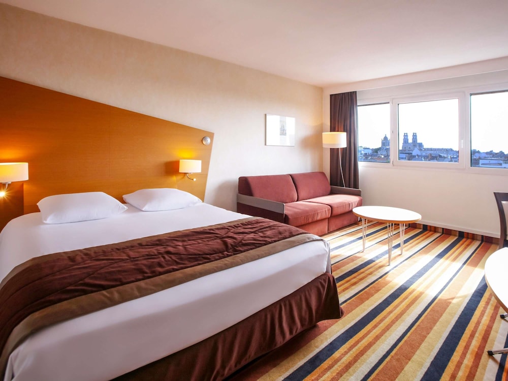 Habitación Superior con cama grande y sofá del hotel Mercure Orléans Centre