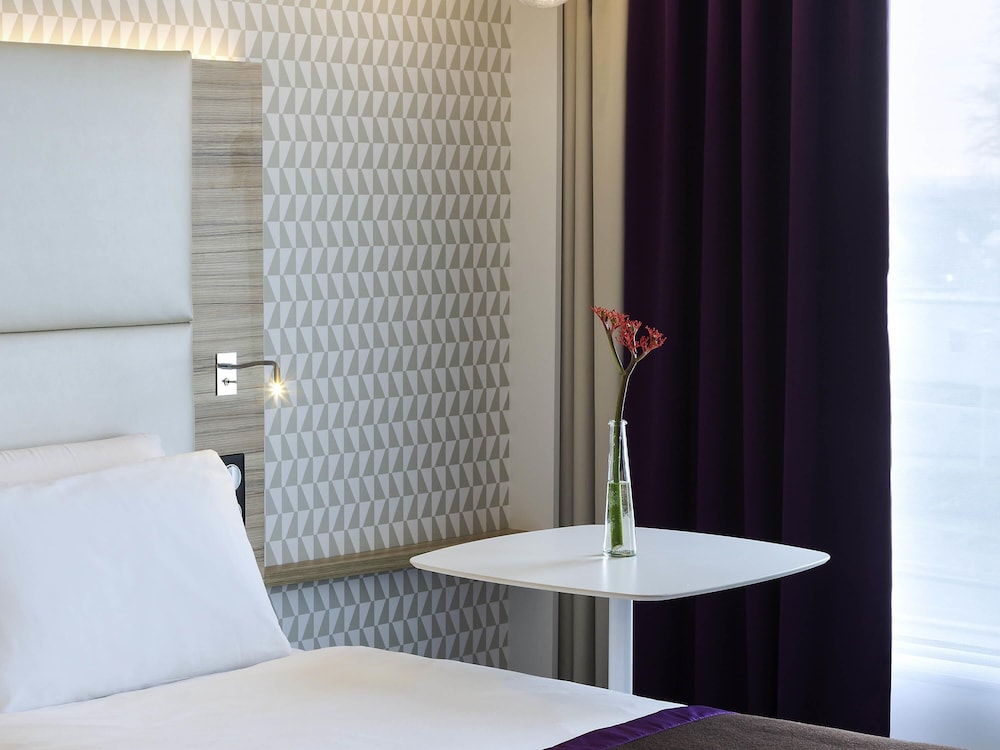 Suite con una cama doble y un sofá cama individual del hotel Mercure Paris Orly Rungis Aéroport