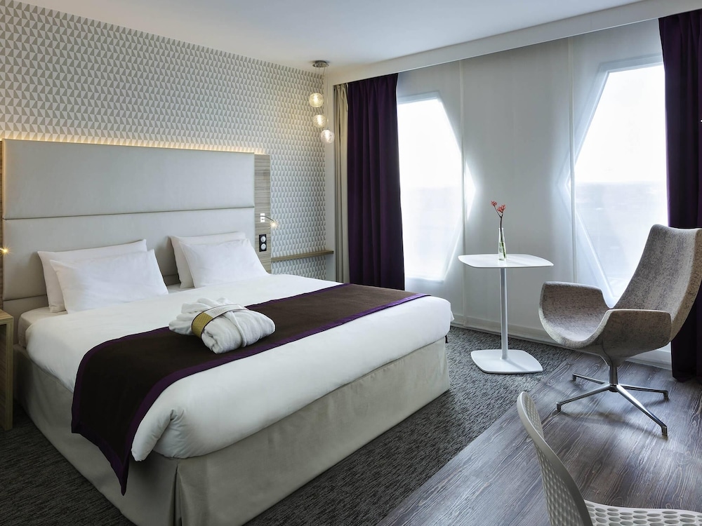 Suite con una cama doble y un sofá cama individual del hotel Mercure Paris Orly Rungis Aéroport. Foto 1