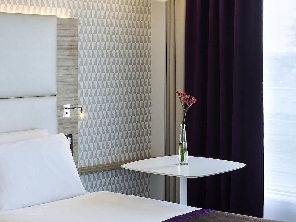 Suite con una cama doble y un sofá cama individual del hotel Mercure Paris Orly Rungis Aéroport. Foto 2