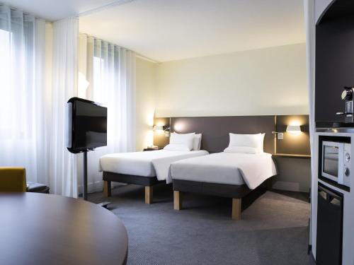 Suite Superior con cama doble y 2 camas individuales del hotel Novotel Suites Paris CDG Airport Villepinte. Foto 10