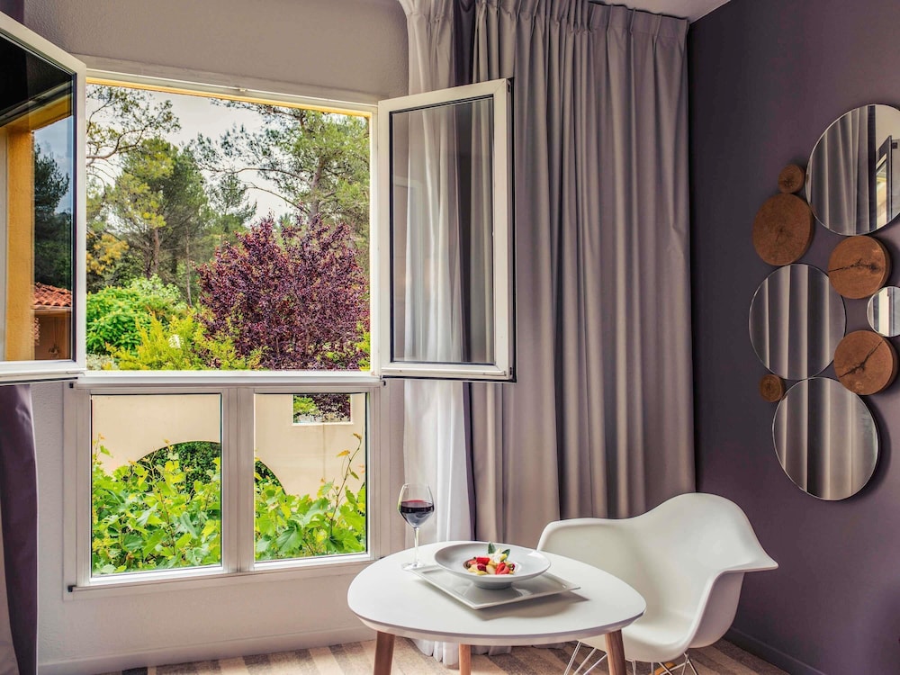 Suite junior con cama doble y sofá del hotel Mercure Antibes Sophia Antipolis