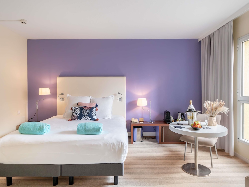 Suite junior con cama doble y sofá del hotel Mercure Antibes Sophia Antipolis. Foto 1
