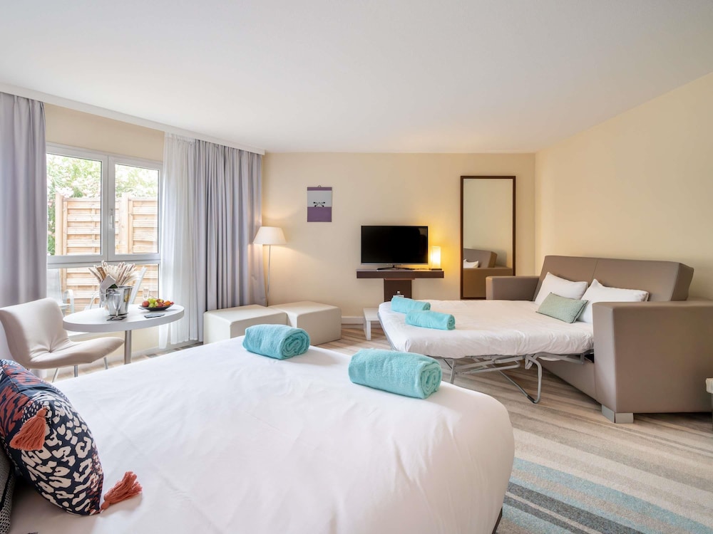 Suite junior con cama doble y sofá del hotel Mercure Antibes Sophia Antipolis