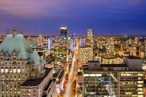 Habitación con cama extragrande y vistas a la ciudad del hotel Hyatt Regency Vancouver. Foto 8