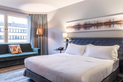 Habitación con cama extragrande y sofá cama del hotel Hilton Helsinki Strand