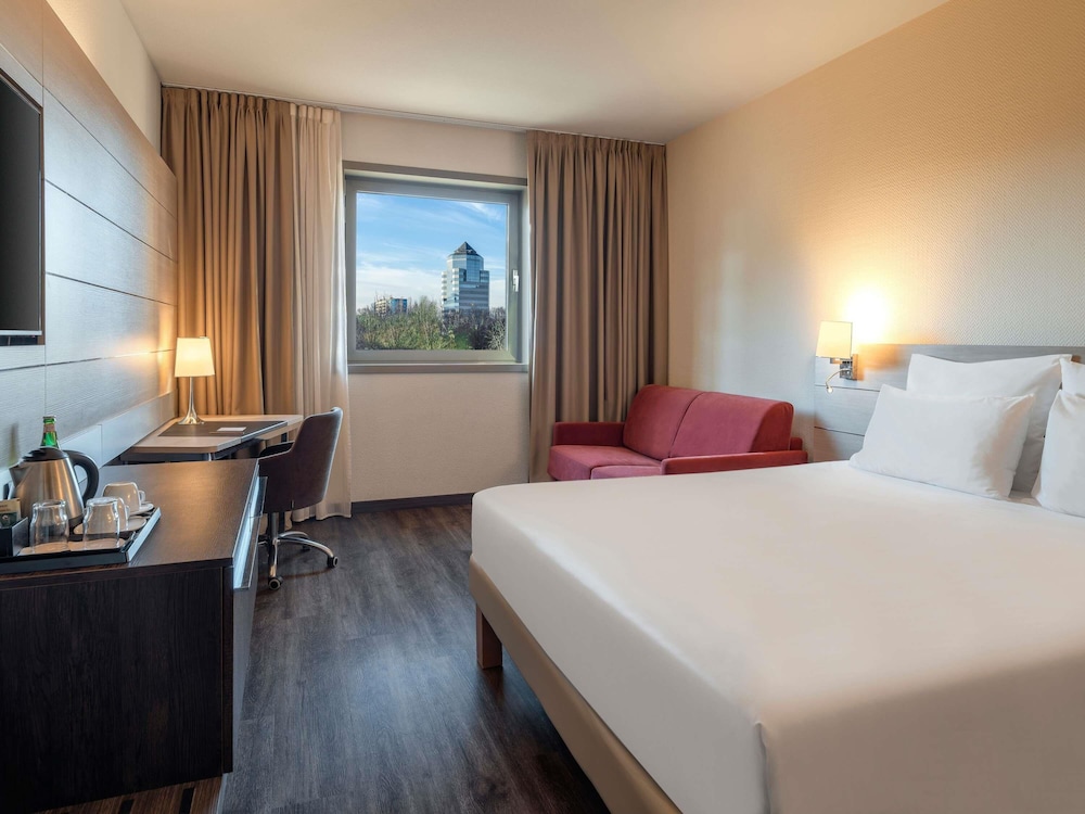 Habitación de categoría superior con una cama king size y un sofá cama del hotel Novotel Brescia 2