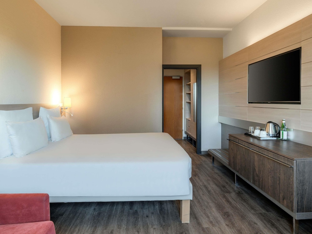 Habitación de categoría superior con una cama king size y un sofá cama del hotel Novotel Brescia 2. Foto 5