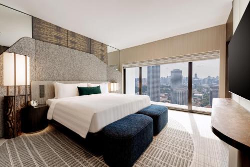 Suite Premier con cama extragrande, vistas a la ciudad y acceso al salón del hotel Pan Pacific Singapore